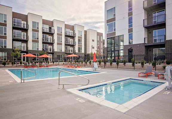 Outdoor pool and hot tub with lounge seating