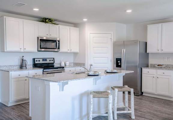 a kitchen with a large island with two stools in front of it