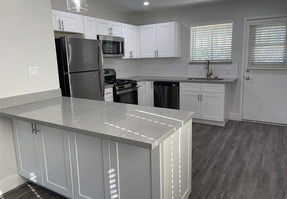 a kitchen with white cabinets and stainless steel appliances