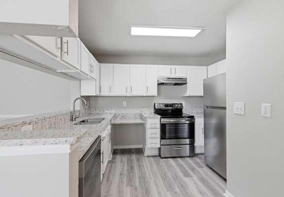 A modern kitchen with stainless steel appliances and white cabinets.
