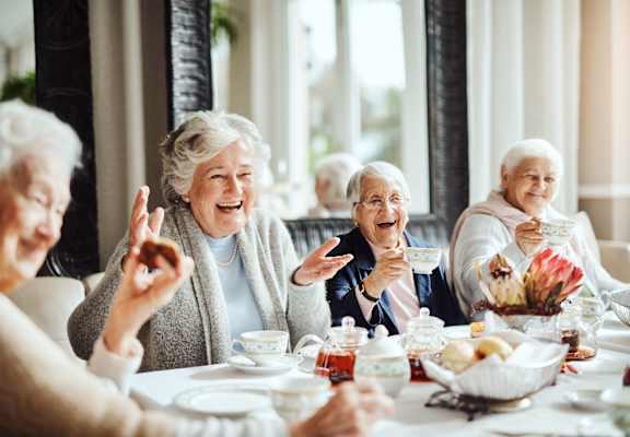 an older group of people sitting around a table eating breakfast at Arbor Hills, Florida, 33805