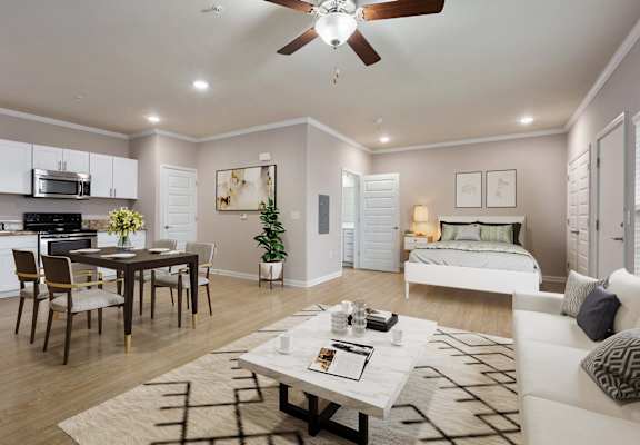 a living and dining room area with a bed in the background and a ceiling fan overhead