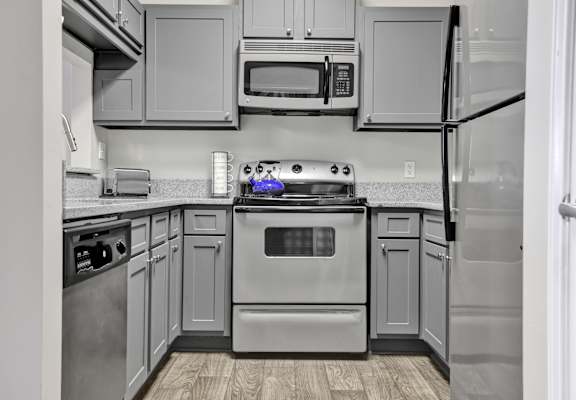 A remodeled kitchen with stainless steel appliances at Village at Caldwell Apartments in Birmingham, AL