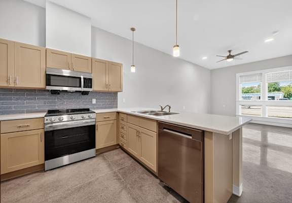 A kitchen with a stove, oven, and microwave.