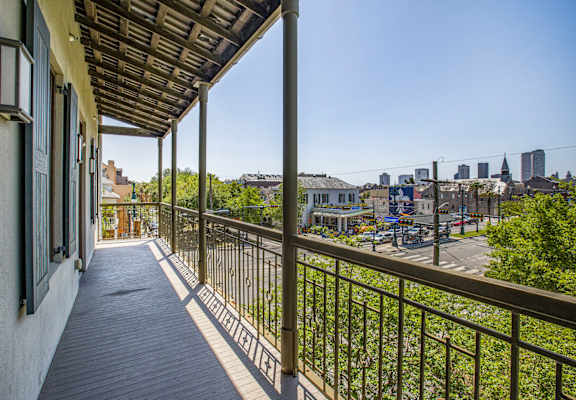 A balcony with a metal railing and a view of a city skyline.