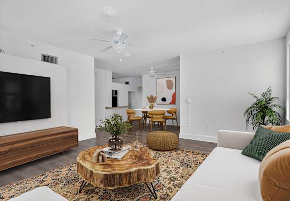 A living room with a white couch and a wooden coffee table.
