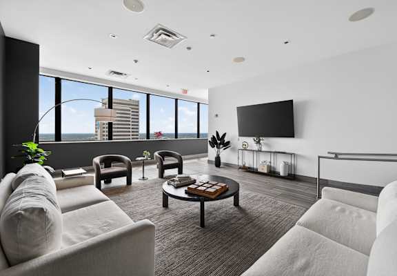 A modern living room with a large window overlooking the city.