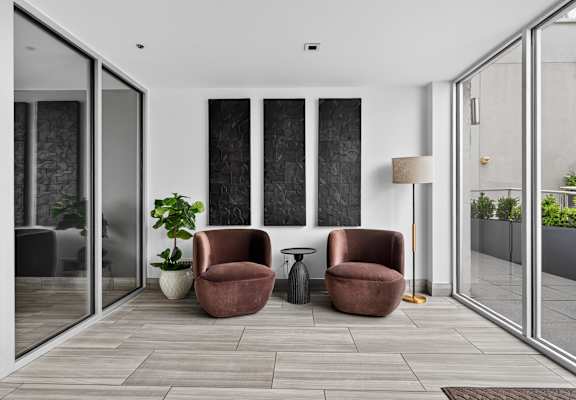 Two chairs and a table are in a room with glass doors.