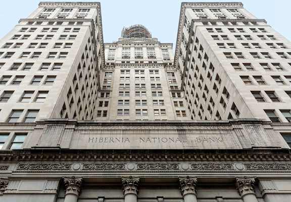 The Hibernia National Bank building is a tall structure with many windows.