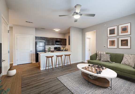 A living room with a green couch, a white coffee table, and a ceiling fan.