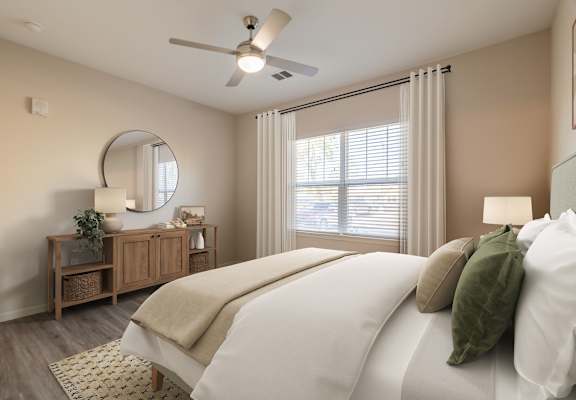 A bedroom with a large bed, a mirror, a dresser, and a ceiling fan.