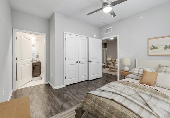 A bedroom with a bed, a dresser, and a ceiling fan.
