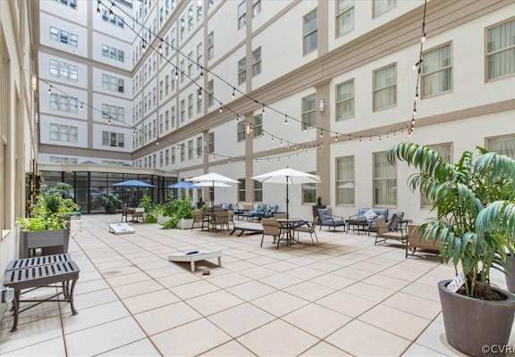 A patio with a table and chairs and a potted plant.