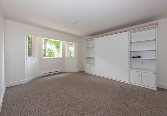 a bedroom with white walls and carpet