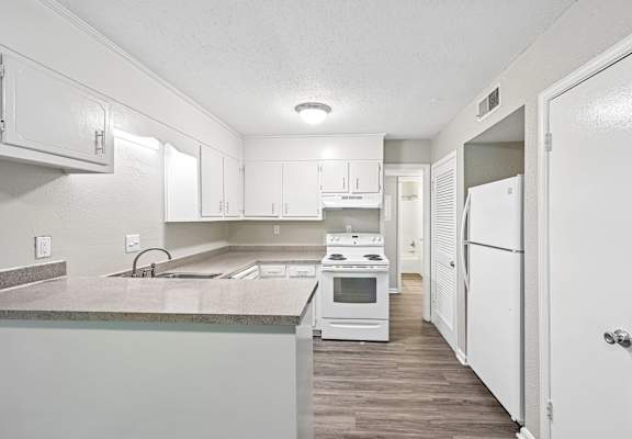 A kitchen with white appliances and cabinets.