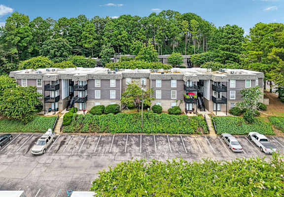 A large apartment complex with a parking lot in front.