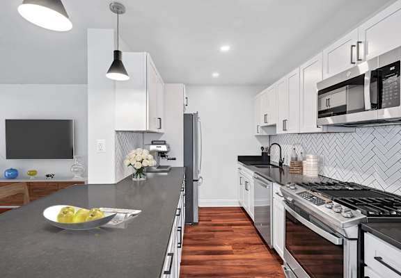 a kitchen with white cabinets and a gray countertop