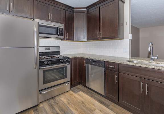 a kitchen with dark wood cabinets and stainless steel appliances