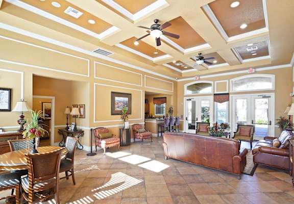 A large room with a brown couch and a ceiling fan.