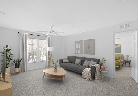 A living room with a grey couch, a wooden coffee table, and a ceiling fan.