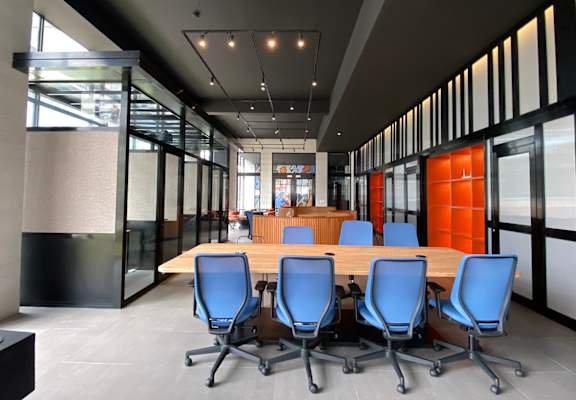 a conference room with a wooden table and blue chairs
