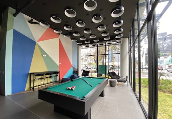 a pool table in the lobby of a building with large windows