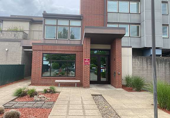 A building with a red brick entrance and glass windows.