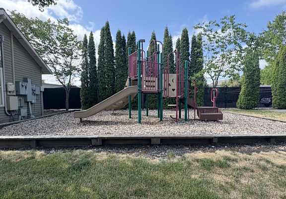 A playground with a slide and swings.