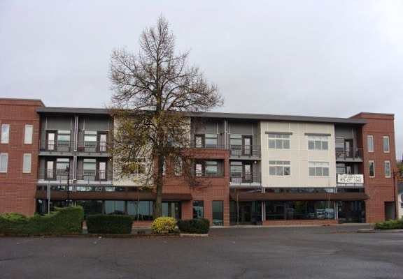 A large building with a parking lot in front.