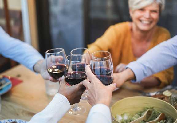 a group of people holding wine glasses over a table