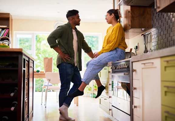 a couple holding hands in a kitchen