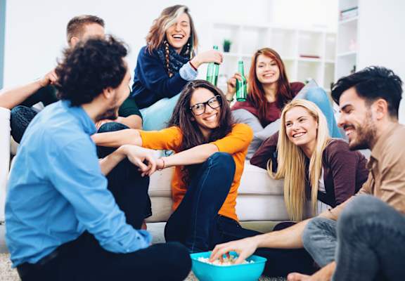 Large group of friends hanging out in apartment at Renew Five Ninety Five, Illinois, 60016