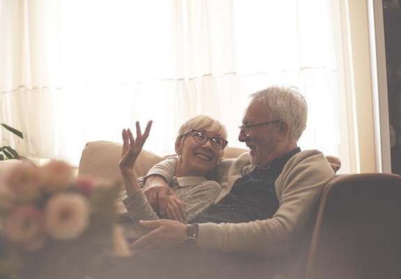 Happy older couple lounging on couch together  at ReNew Sugar Hill, Sugar Hill, GA