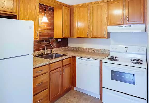 a kitchen with white appliances and wooden cabinets at Stonebridge, Ellington, CT, 06029