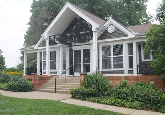 A house with a white front porch and a black roof.