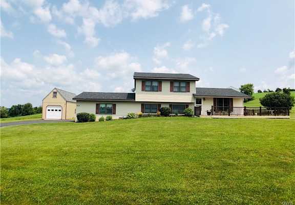a house on a hill with a grassy area in front of it