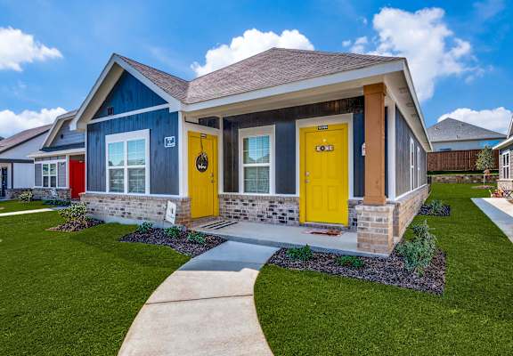 the front of a house with yellow doors