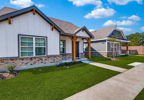 a home with a sidewalk and lawn in front of it