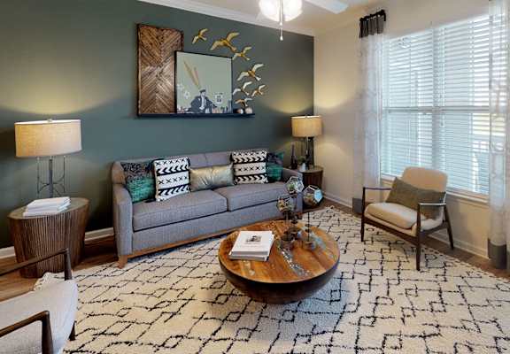 Living room with couch and chair; door to patio or balcony