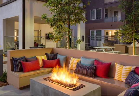 A patio with a fire pit and couches.