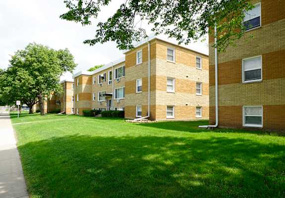 an apartment building with a lawn in front of it