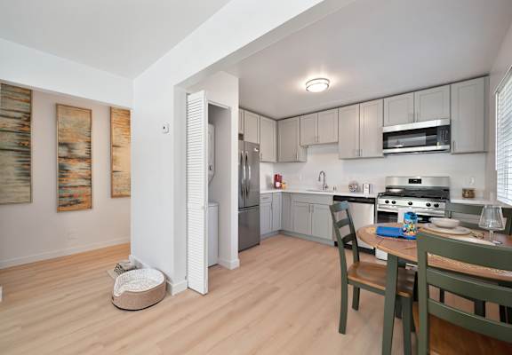 A kitchen with a table and chairs in it.