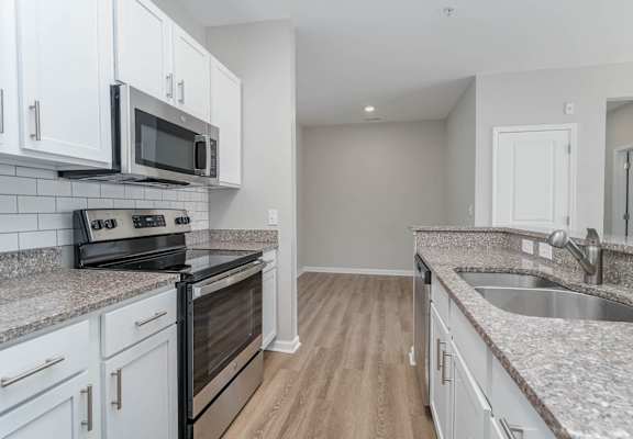 a kitchen with granite counter tops and white cabinets