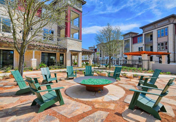 a fire pit with green adirondack chairs in the courtyard at Park at Rialto Apartments, San Antonio, TX 78257arge Balcony at Park at Rialto Apartments, San Antonio