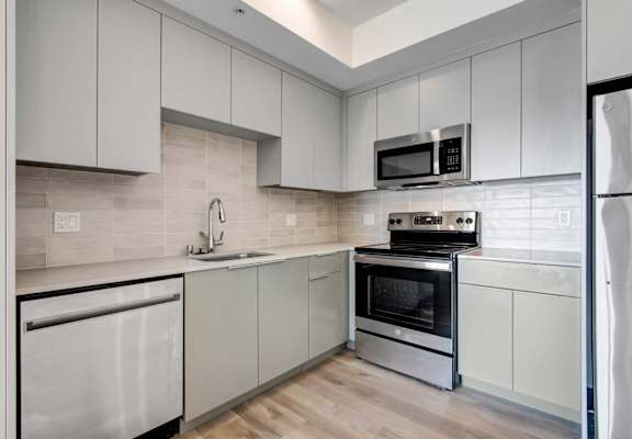 a kitchen with white cabinets and stainless steel appliances
