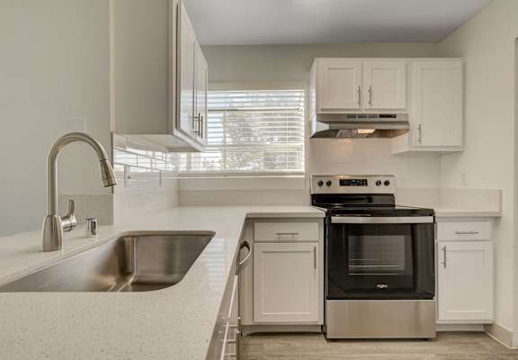 a kitchen with white cabinets and stainless steel appliances