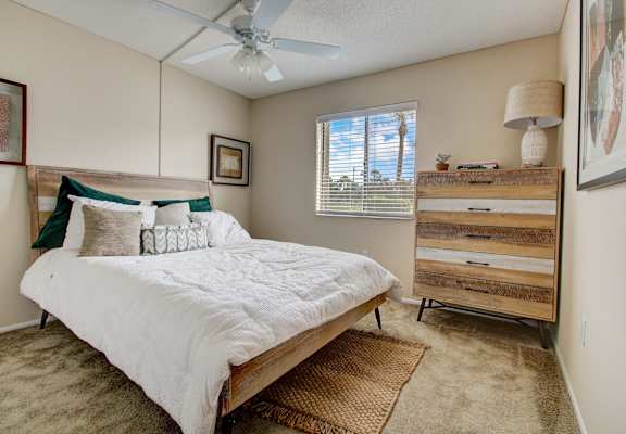 a bedroom with a bed and a ceiling fan