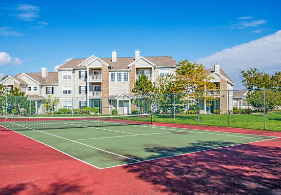 A tennis court in front of a large apartment building at Amhurst Lake Apartments, Waukegan, Illinois