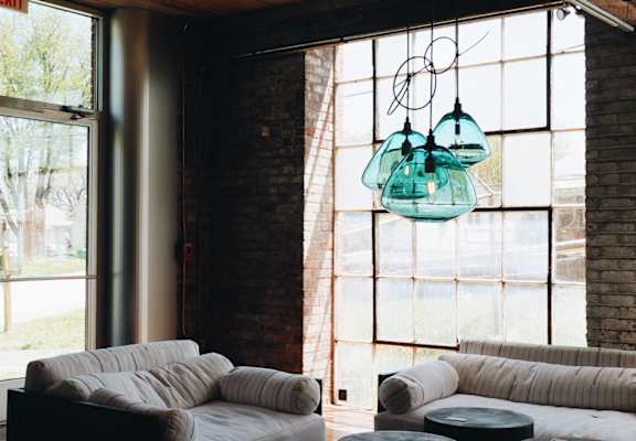 A living room with a white couch and a glass chandelier.