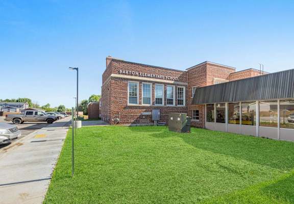 A brick building with a sign that says Barton Elementary School.